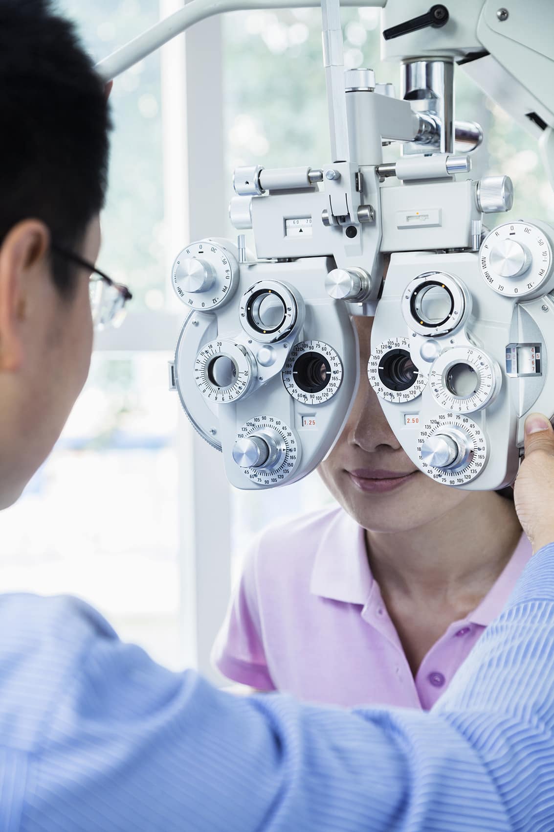 Optometrist doing an eye exam on young woman Optometrist doing an eye exam on young woman