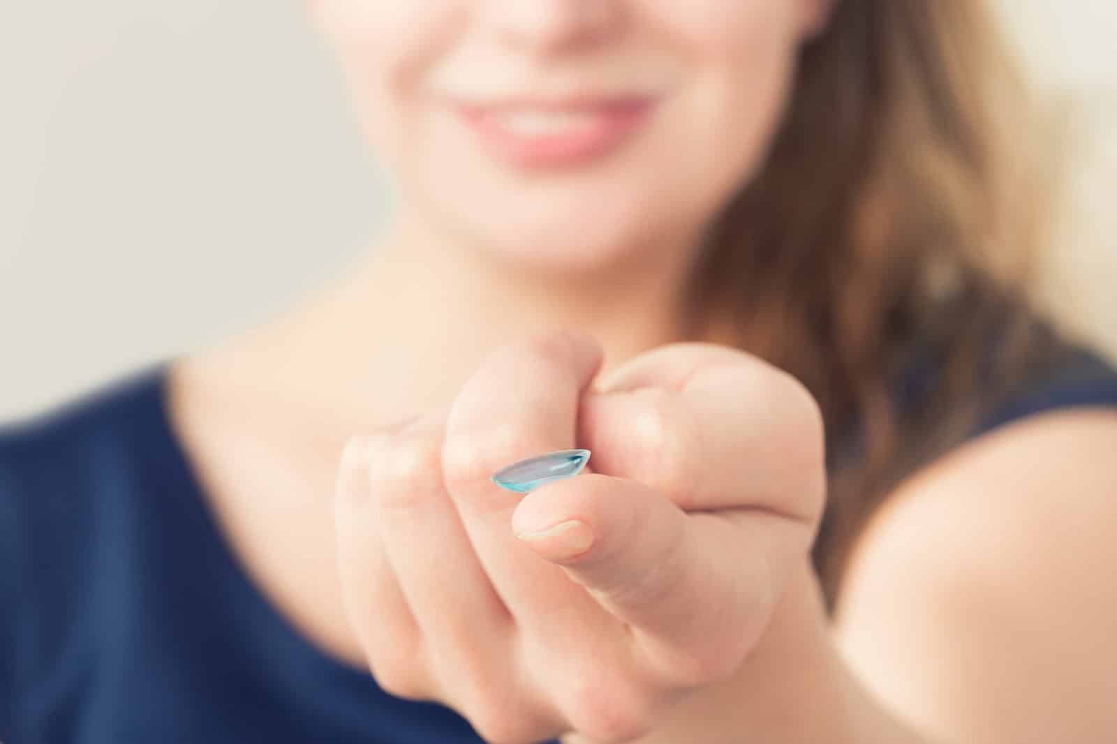 Woman inserting a contact lens in eye. Woman inserting a contact lens in eye.
